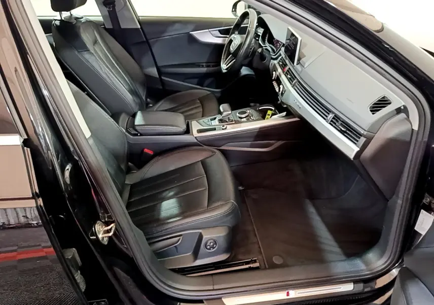Intérieur noir de l'Audi A4 40 TDI 2018 vu côté conducteur, avec sièges cuir et tableau de bord moderne.