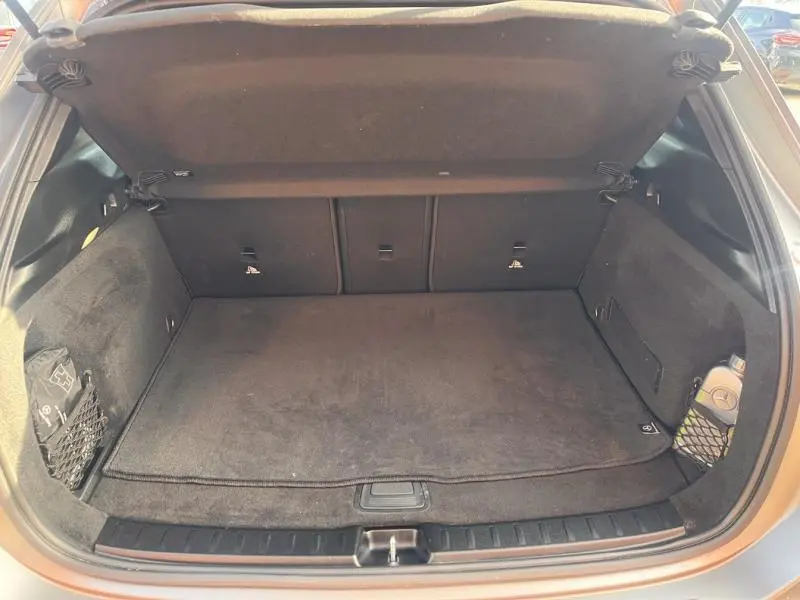 Coffre ouvert du Mercedes GLA 200 d AMG Line gris montagne magno, montrant un espace de rangement propre et bien agencé.