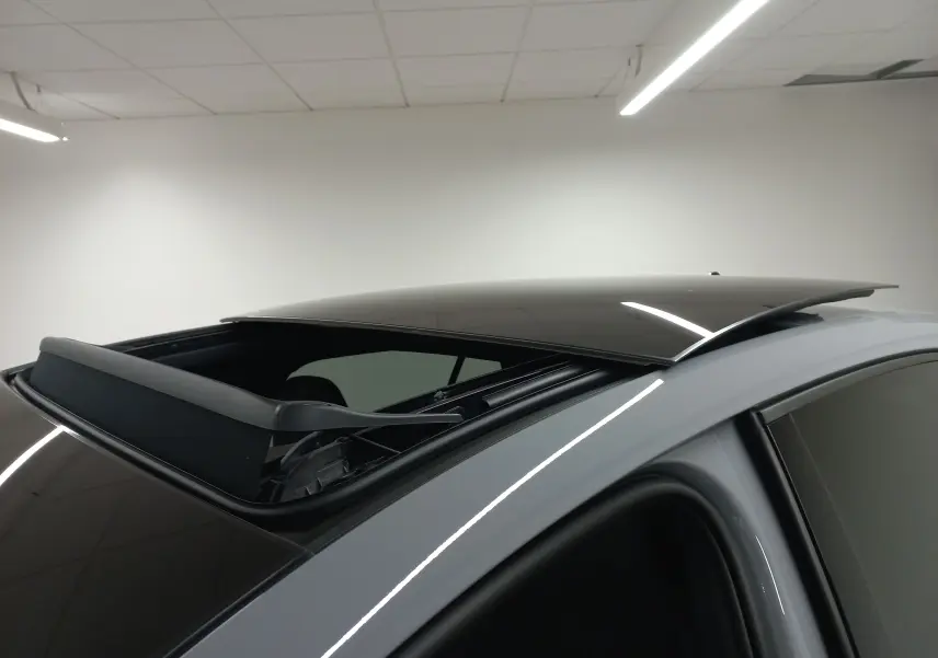 Toit ouvrant panoramique ouvert vu en gros plan sur le côté gauche d'une Volkswagen Golf gris lunaire.