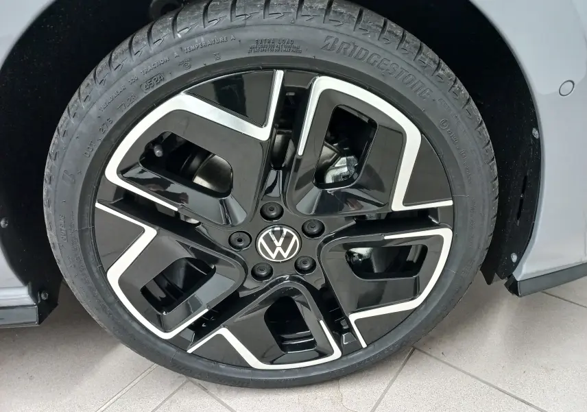 Gros plan sur la roue avant droite de la Volkswagen Golf 2.0 TDI R-Line gris lunaire avec jante noire et argentée.