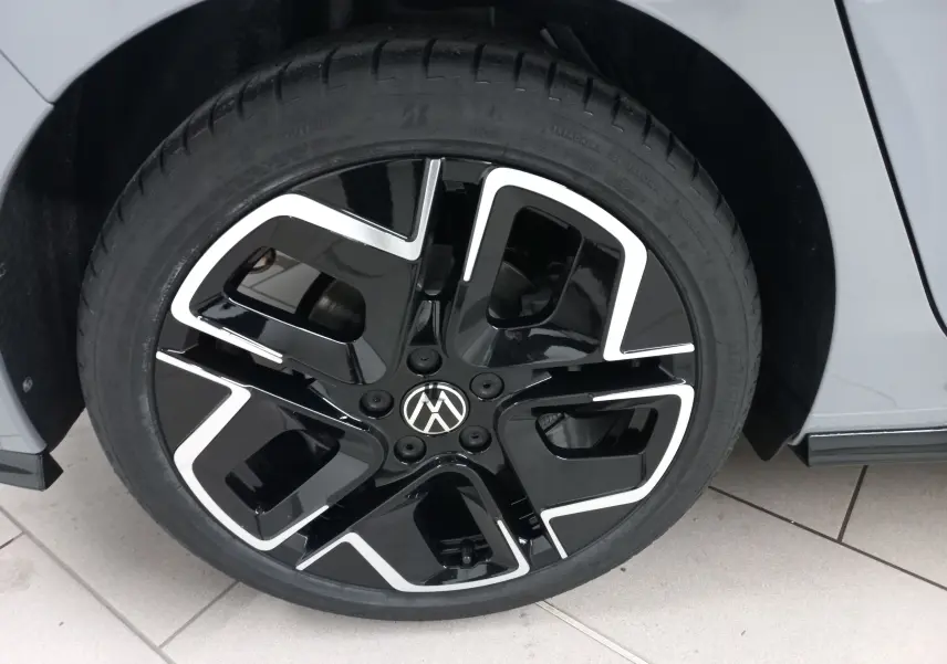 Gros plan sur la roue avant droite de la Volkswagen Golf gris lunaire avec jante noire et détails argentés R-Line.