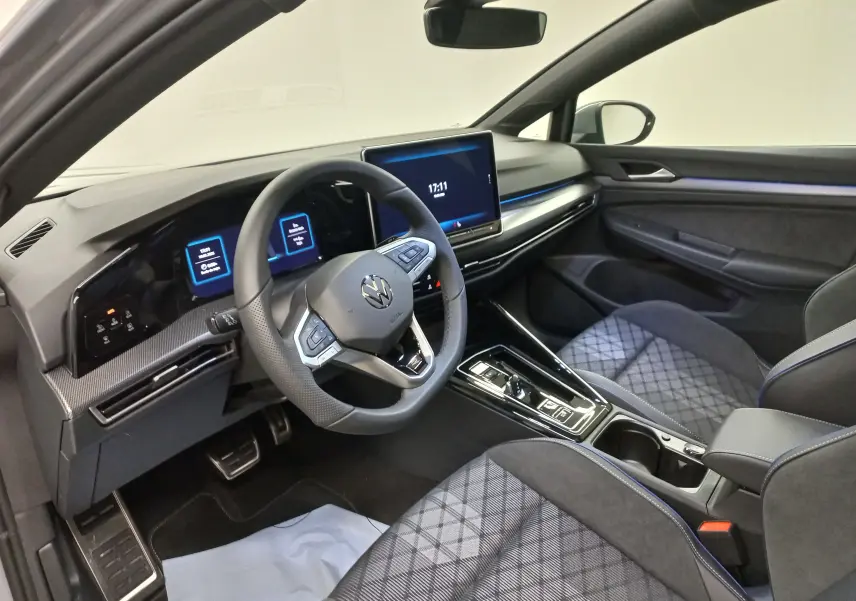 Vue intérieure côté conducteur de la Volkswagen Golf 2.0 TDI R-Line 2026 avec sièges tissu gris et tableau de bord numérique.