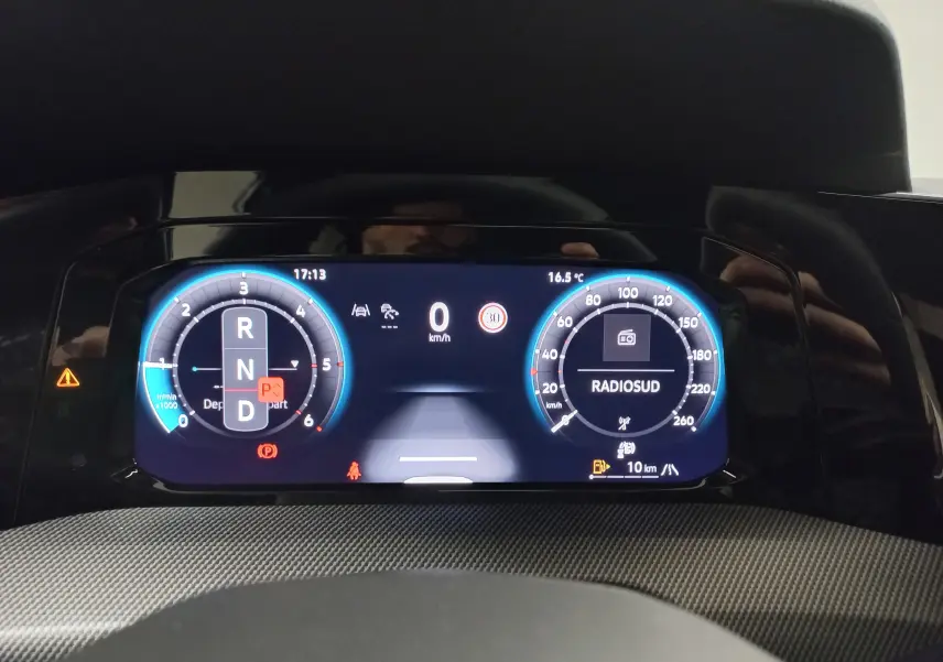 Vue rapprochée du tableau de bord numérique de la Volkswagen Golf 2.0 TDI 150 DSG7 R-Line, affichage vitesse et radio.