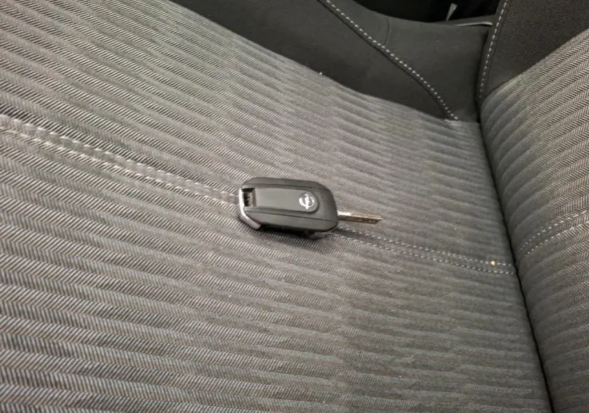 Gros plan sur la clé Opel posée sur la sellerie tissu noire de la banquette arrière de la Corsa 2023.