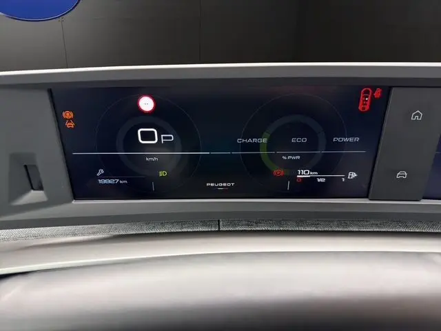 Tableau de bord numérique du Peugeot 5008 Allure Hybrid blanc, affichant la vitesse à 0 km/h et les indicateurs d'énergie.