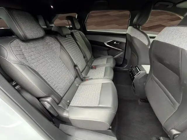 Vue latérale intérieure du rang 2 du Peugeot 5008 Allure Hybrid 145, sièges tissu gris et cuir noir avec surpiqûres Quartz.