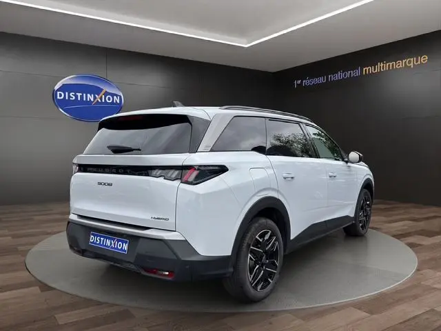 Vue 3/4 arrière droite du Peugeot 5008 Nouveau blanc Okenite avec jantes alliage noires et bandeau noir laqué entre feux arrière.