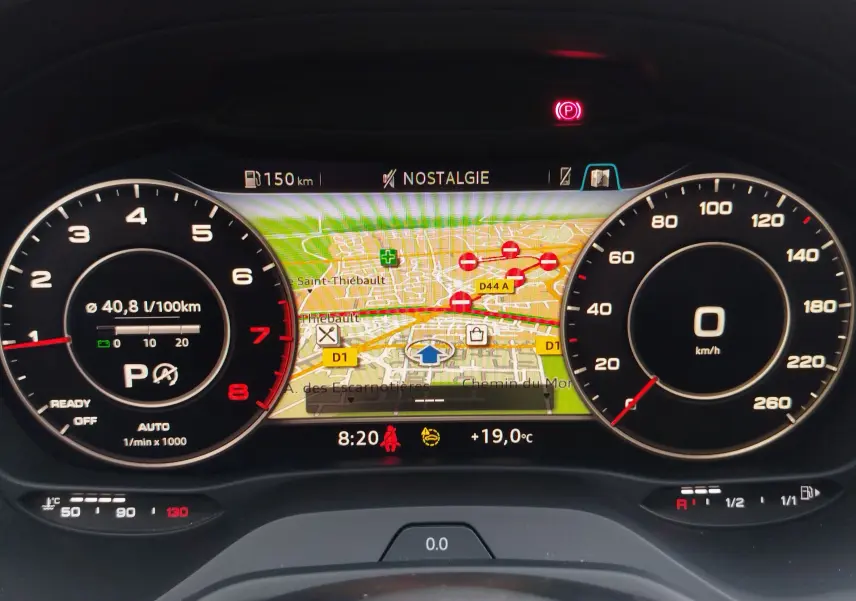 Vue rapprochée du tableau de bord numérique de l'Audi Q2 2023, affichant la navigation et les compteurs.