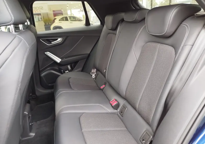 Vue intérieure arrière droite des sièges en cuir gris foncé de l'Audi Q2 35 TFSI S line 2023, avec détails de couture apparents.