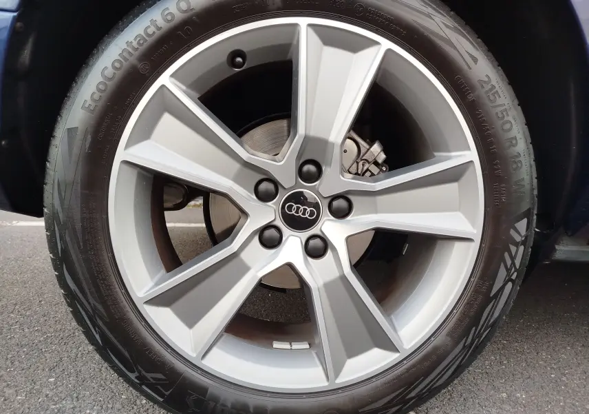 Gros plan sur la jante alliage 18 pouces et pneu Continental d’un Audi Q2 bleu Navarre, version 35 TFSI S line.
