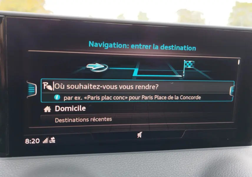 Écran de navigation intérieur de l'Audi Q2 2023 affichant la saisie de destination avec interface moderne et fond noir.