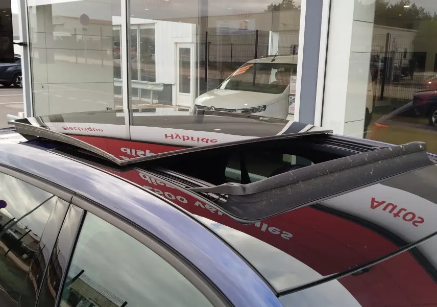 Toit ouvrant relevé vu de dessus sur un Audi Q2 bleu Navarre, mettant en valeur la finition S line 2023.