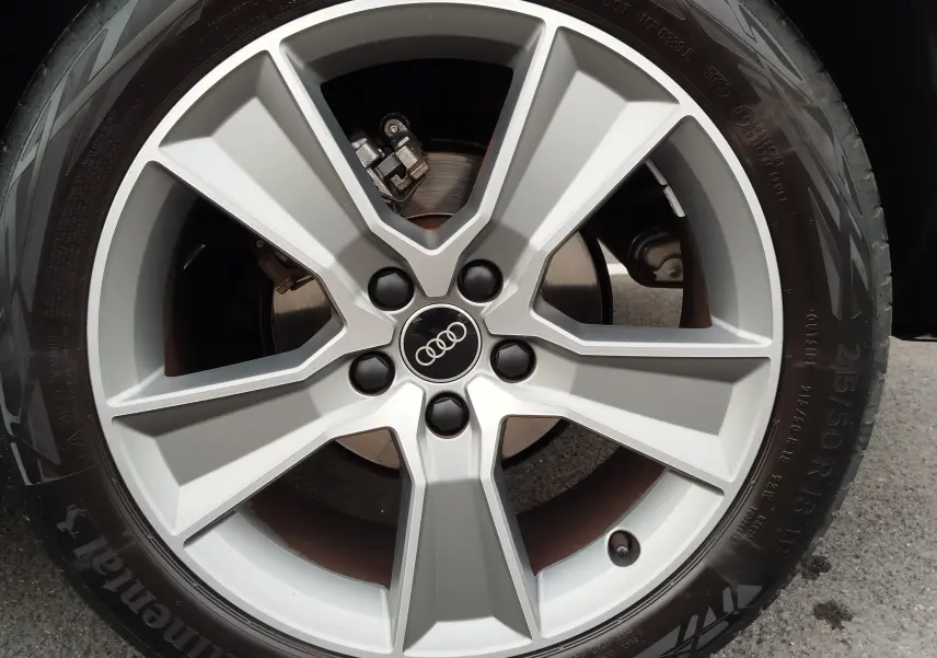 Gros plan sur la jante en alliage argentée avec logo Audi au centre, montée sur pneu Continental.