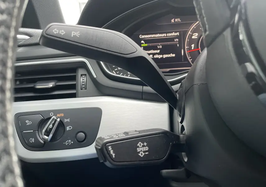 Gros plan sur les commandes au volant et tableau de bord numérique d'une Audi S4 2016 avec finition intérieure gris clair.