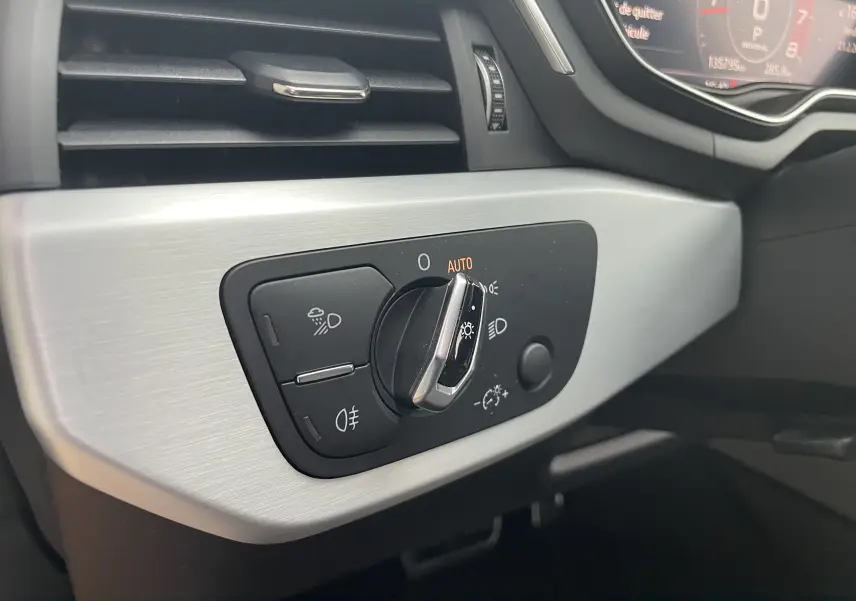 Gros plan sur la commande des phares à gauche du tableau de bord intérieur gris d'une Audi S4 2016.