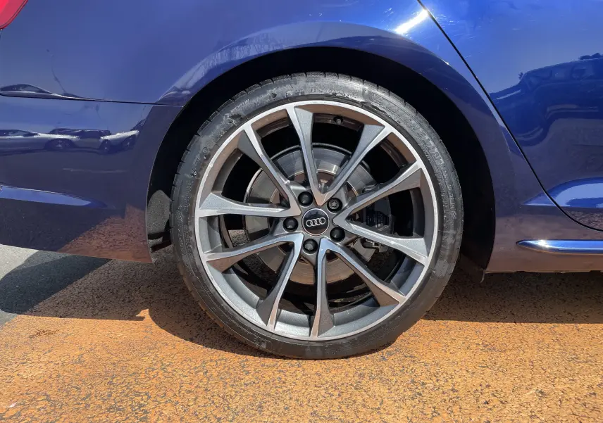 Gros plan sur la roue arrière droite bleu Navarre d'une Audi S4 2016 avec jante alliage à 10 branches doubles.