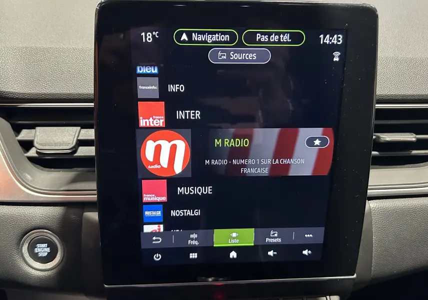 Écran tactile central du Renault Captur 2024 affichant les stations radio, avec bouton Start Engine Stop à gauche.