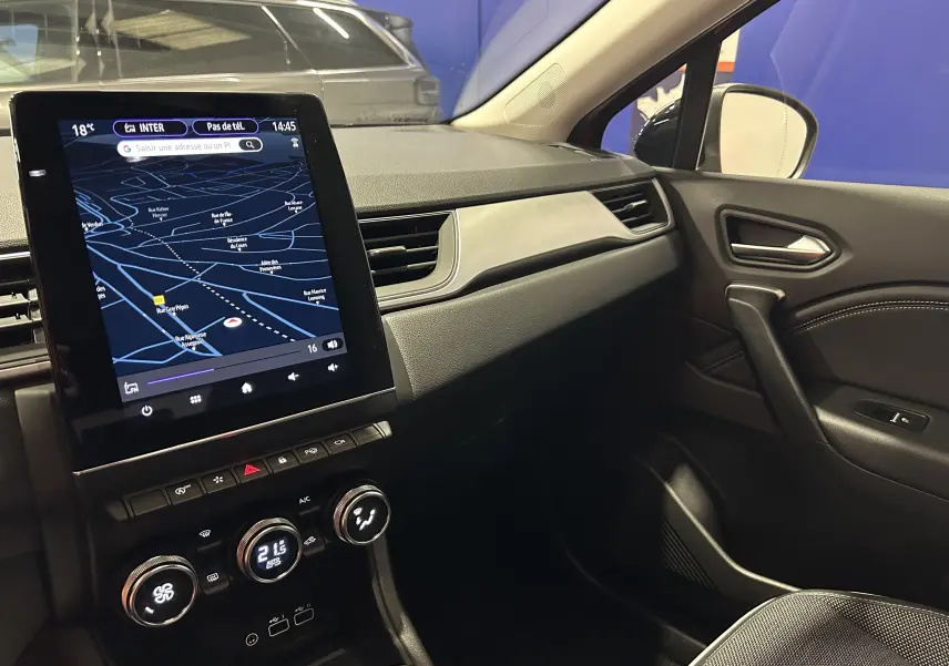 Vue intérieure côté passager du tableau de bord du Renault Captur 2024 avec écran tactile et commandes de climatisation.