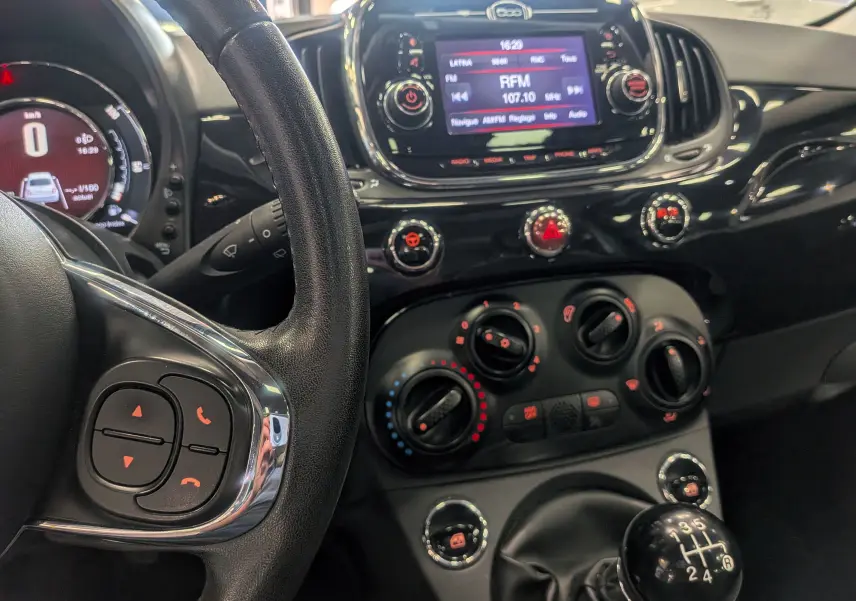 Intérieur noir de la Fiat 500 1.2 Lounge 2017, vue du tableau de bord et levier de vitesse manuel au centre.