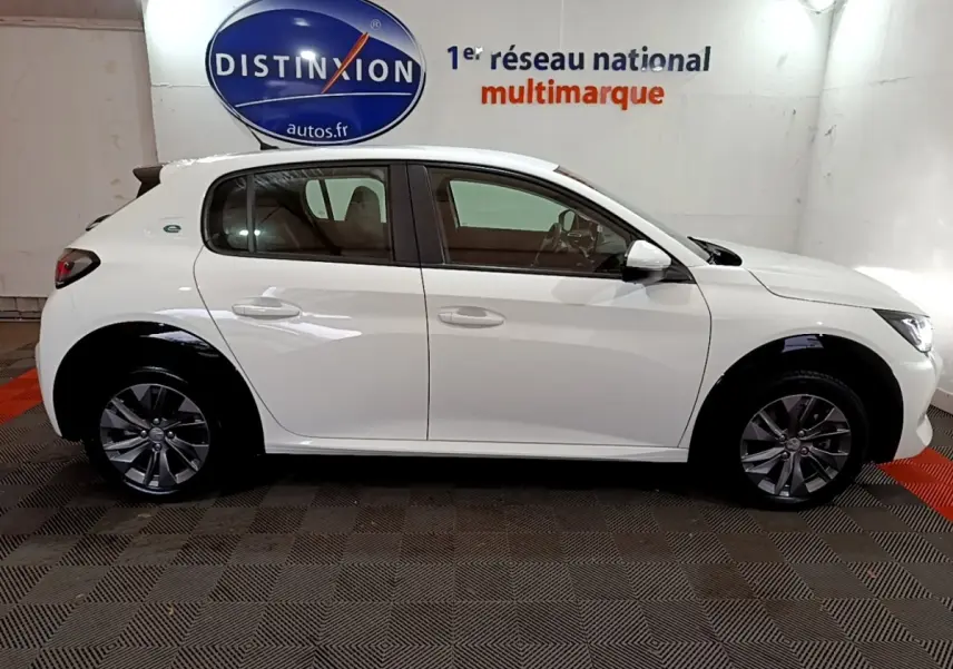 Profil côté gauche d'une Peugeot 208 électrique Active Business blanche, avec jantes alliage et logo e-208 visible.