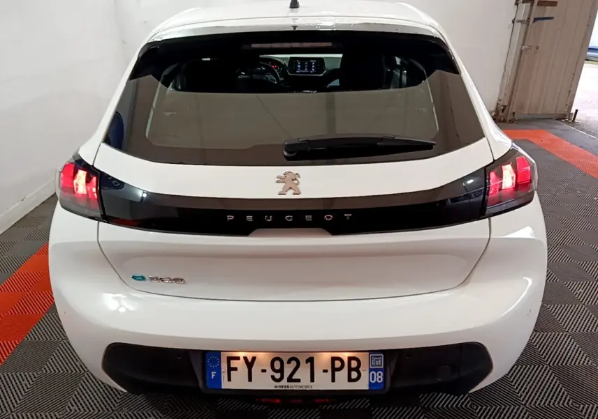 Vue arrière d'une Peugeot 208 électrique Active Business blanche avec feux LED allumés en intérieur.