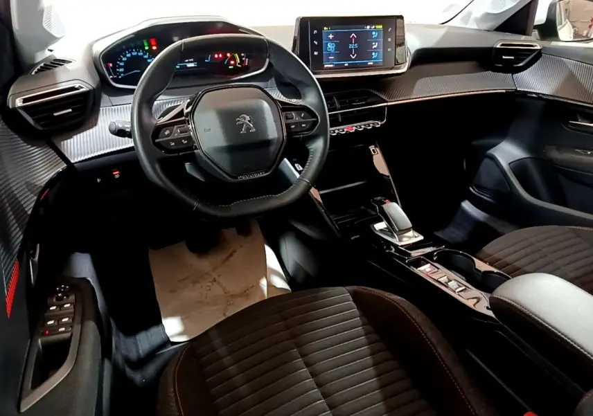 Intérieur noir de la Peugeot 208 Electrique Active Business 2021, vue du poste de conduite avec volant compact et écran tactile central.