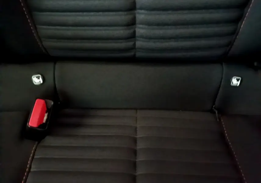 Gros plan sur la banquette arrière noire de la Peugeot 208 Electrique Active Business avec ceintures et fixation Isofix visibles.