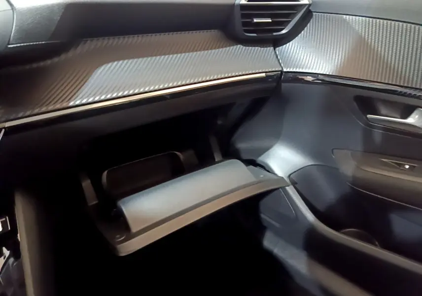 Intérieur Peugeot 208 Electrique Active Business 2021, vue côté passager sur boîte à gants ouverte et tableau de bord noir.