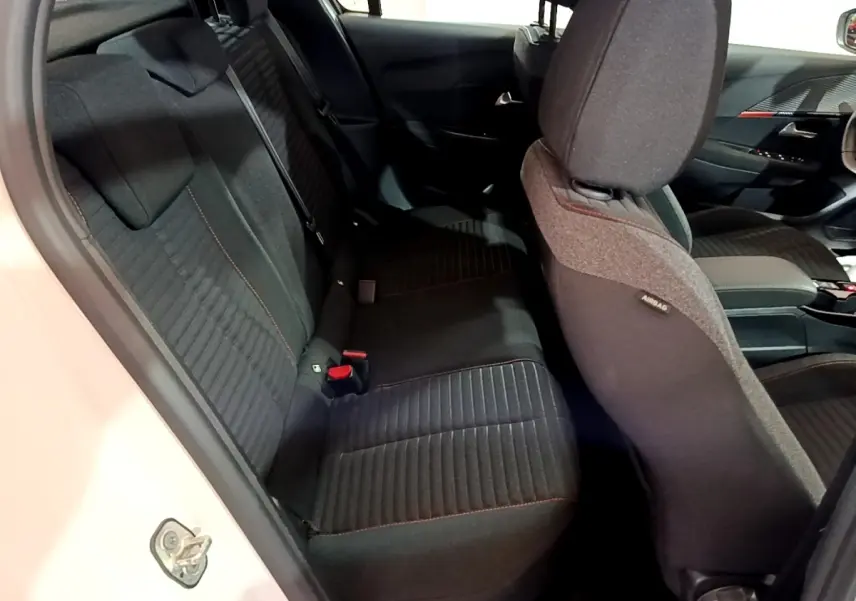 Vue intérieure côté gauche de la banquette arrière noire avec surpiqûres rouges d'une Peugeot 208 blanche Electrique Active Business 2021.
