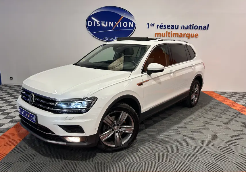 Volkswagen Tiguan Allspace blanc en 3/4 avant droit avec jantes alliage et phares LED allumés.