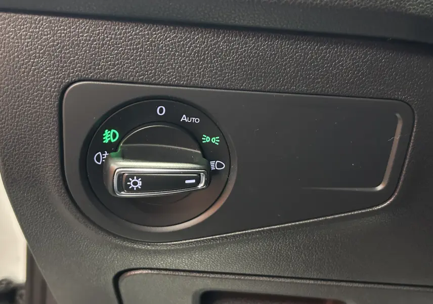 Gros plan sur la commande d'éclairage du Volkswagen Tiguan Allspace blanc, avec réglage sur feux automatiques.