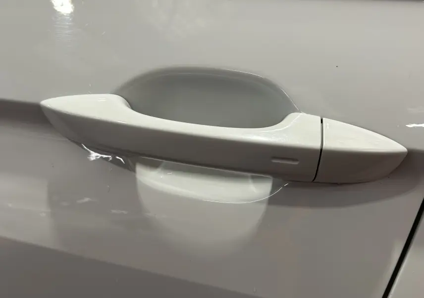 Poignée de porte blanche en gros plan sur le côté gauche d'un Volkswagen Tiguan Allspace 2018.