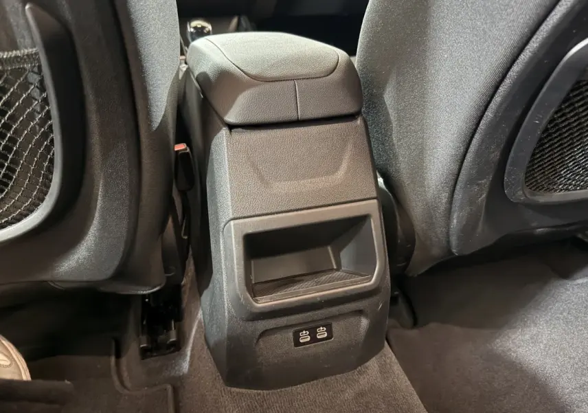 Détail de la console centrale arrière avec ports USB visibles entre les sièges avant d'une BMW Série 1 blanche 2023.