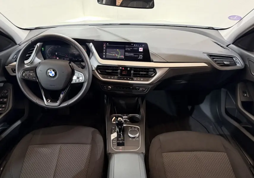 Vue intérieure avant du tableau de bord et volant cuir noir de la BMW Série 1 116i Business Design 2023.