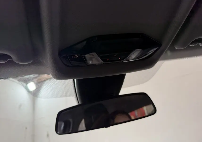 Vue intérieure rapprochée du plafonnier et du rétroviseur intérieur d'une BMW Série 1 blanche de 2023.
