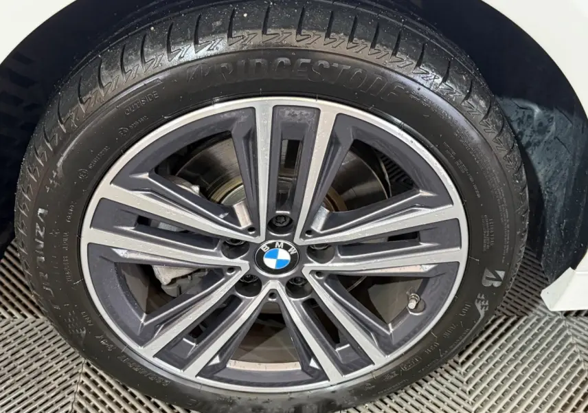 Gros plan sur la jante alliage BMW à 10 branches de la BMW Série 1 blanche, pneu Bridgestone visible.