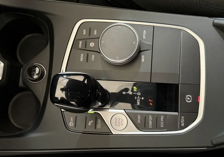 Vue rapprochée de la console centrale noire de la BMW Série 1 116i avec levier de vitesses automatique et commandes de modes de conduite.