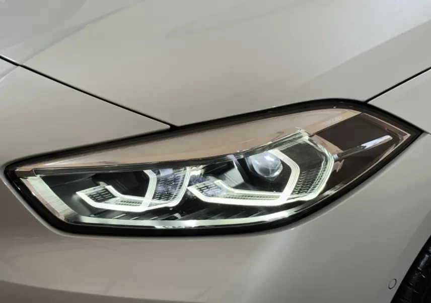 Gros plan sur le phare avant droit LED blanc d'une BMW Série 1 116i Business Design 2023.