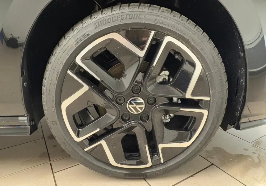 Gros plan sur la roue avant gauche de la Volkswagen Golf 2.0 TDI 150 DSG7 R-Line noir grenadille avec jante alliage noire et argent.