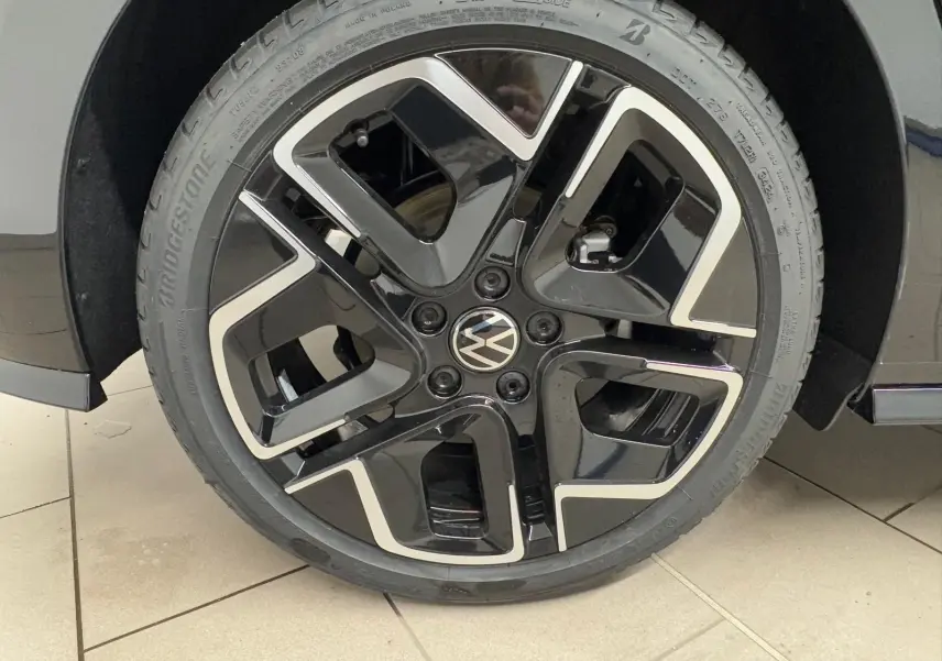 Gros plan sur la roue avant droite noire et argentée d'une Volkswagen Golf 2.0 TDI 150 DSG7 R-Line.