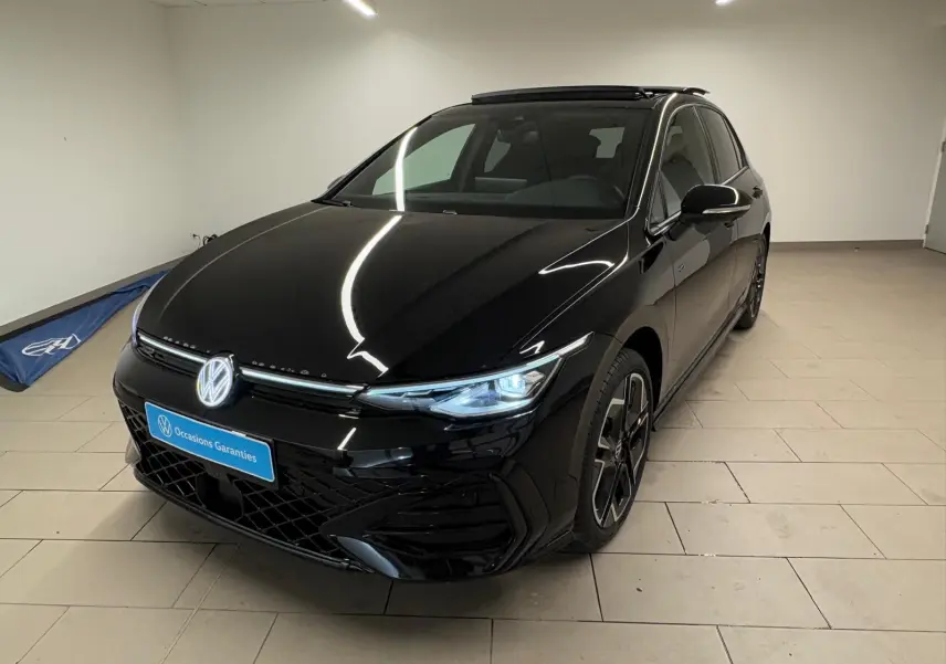 Volkswagen Golf 2.0 TDI R-Line noir grenadille vue 3/4 avant avec phares allumés dans un intérieur neutre.