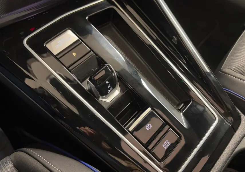 Vue rapprochée de la console centrale noire brillante de la Volkswagen Golf 2.0 TDI 150 DSG7 avec sélecteur de vitesse automatique.