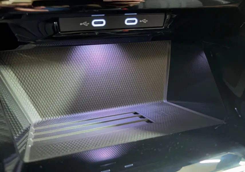 Gros plan sur la zone de recharge avec ports USB-C et éclairage intérieur violet dans une Volkswagen Golf Noir Grenadille.