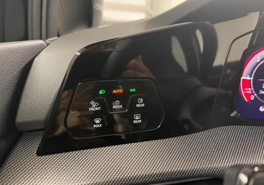 Détail du tableau de bord noir de la Volkswagen Golf 2.0 TDI 150 DSG7 R-Line avec commandes d'éclairage et affichage digital partiel.