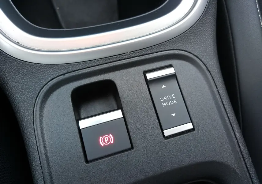Gros plan sur la console centrale noire du Jeep Avenger eHYBRID avec bouton frein à main électronique et sélection mode de conduite.