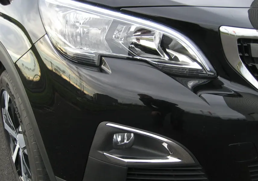 Gros plan sur l'avant droit noir du Peugeot 3008 2020, mettant en valeur le phare et le feu antibrouillard chromé.