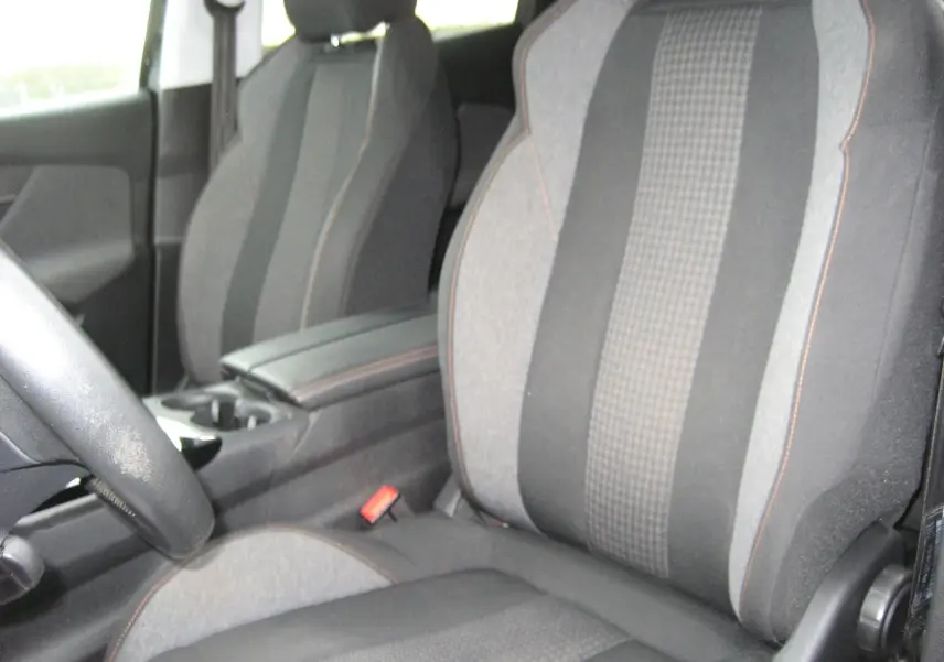 Intérieur du Peugeot 3008 Business 2020, vue rapprochée des sièges avant en tissu gris avec surpiqûres orange.