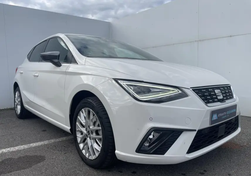 SEAT Ibiza blanche vue en 3/4 avant droit, avec jantes alliage et feux LED à signature triangulaire.