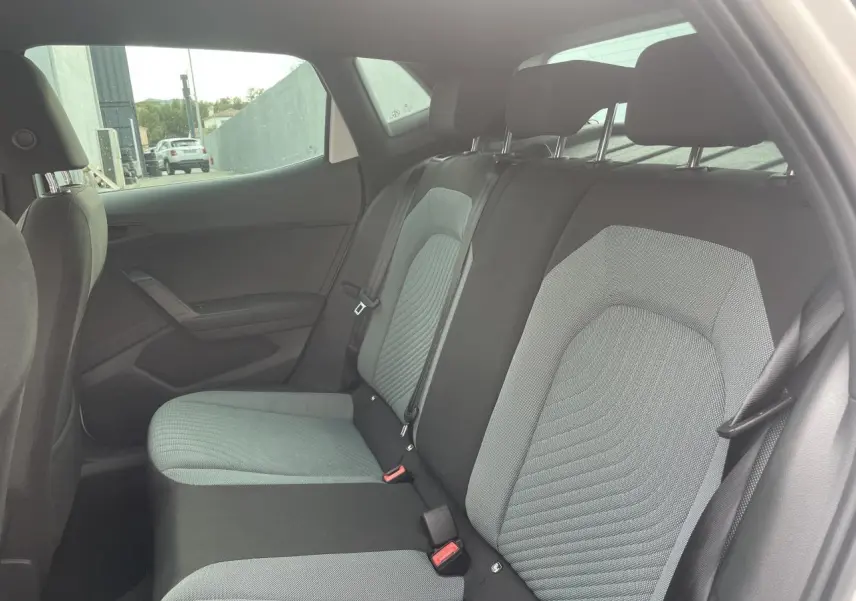 Vue intérieure côté droit sur la banquette arrière en tissu gris et noir d'une SEAT IBIZA blanche 2025.