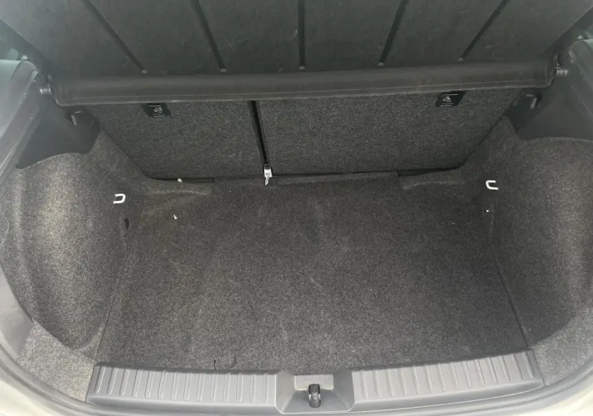 Coffre ouvert de la SEAT Ibiza blanche 2025, montrant un espace de rangement propre et doublé de moquette grise.